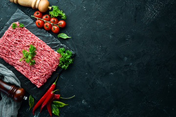 Minced meat. Meat and spices on the old table. Top view. Free space for your text.