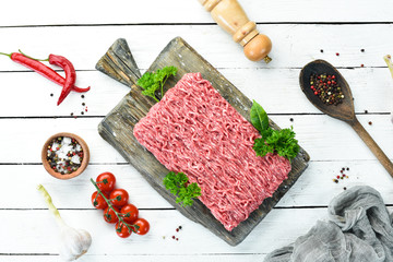 Minced meat. Meat and spices on the old table. Top view. Free space for your text.