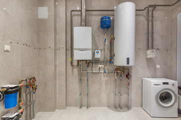 Wall hung gas boiler and electric water heater in boiler room