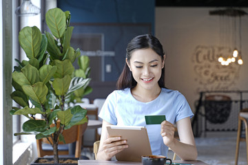 Asian pretty attractive woman sitting in coffee shop using smart phone