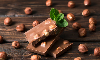 Chocolate pieces with nuts on  wooden background