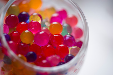 In the glass staan are round colored candies.