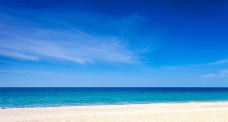 Obraz premium Tropical sandy beach with blue ocean and blue sky background image for nature background or summer background