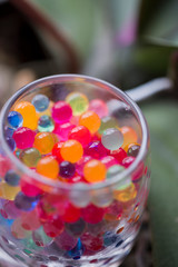 In the glass staan are round colored candies.