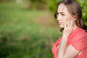 Close-up Of Female Hands Putting Hearing Aid In Ear. Modern digital in the ear hearing aid for...