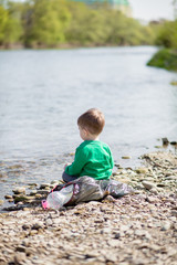 Save environment concept, a little boy collecting garbage and plastic bottles on the beach to dumped into the trash.