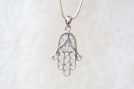 Silver hamsa Fatima hand pendant on natural white background