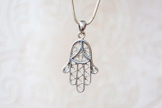 Silver hamsa Fatima hand pendant on natural white background