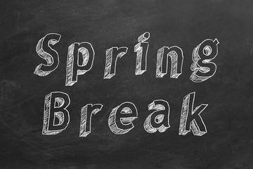 Hand drawing text "Spring Break" on blackboard