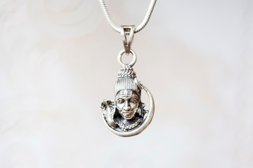 Silver Shiva head pendant on natural white background
