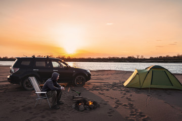 Fototapeta na wymiar Man at campfire at sunset