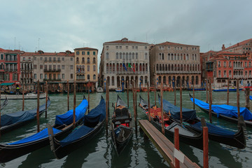 Venice, Italy - 2019 January 18: Covered Gondolas atz the Canale Grande ("Grand Canal") on a cloudy Winter Day