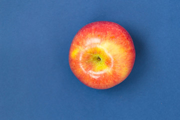 Red apple on blue background. There is a place for text.