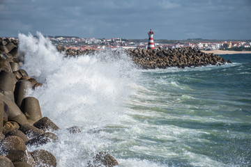 Fototapeta na wymiar Ocean surf and lighthouse on the pier in Peniche Portugal