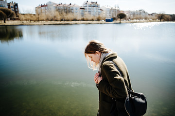beautiful girl in coat walking outdoors, woman is resting in nature