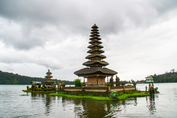 Fototapeta na wymiar Moody scenic landscape view of Pura Ulun Danu Bratan, Hindu water temple on Bratan lake, tourist most popular attraction in Bali island, Indonesia.