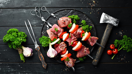 Raw pork shish kebab. BBQ meat with vegetables and spices. Top view. Free space for your text. Rustic style.