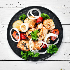 Barbecue chicken on skewers with onions and tomatoes. Barbecue. Top view. Free space for your text. Rustic style.