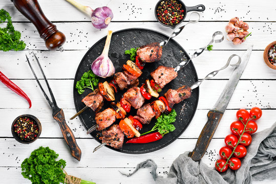 Pork shish kebab with onions and tomatoes. Barbecue. Top view. Free space for your text. Rustic style.