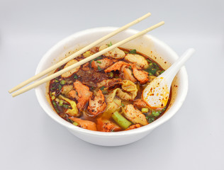 The image of yellow noodles in spicy soup is Thai food on a separate white background.