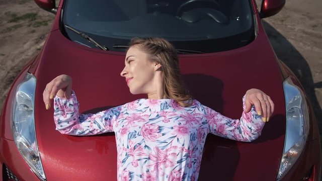 The girl is very gentle on the hood of the car. 4K Slow Mo