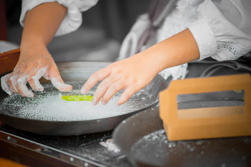 The cook's hand is cooking with delicacy.