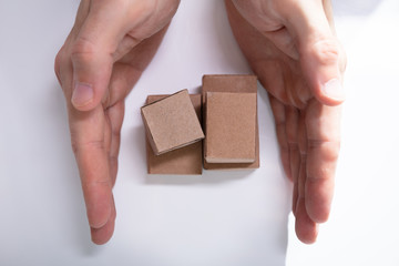 Close-up Of Hand Holding Miniature Movable Cardboard Boxes