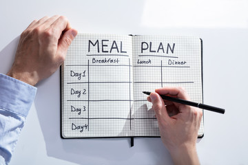 Filling Meal Plan In Notebook At Desk