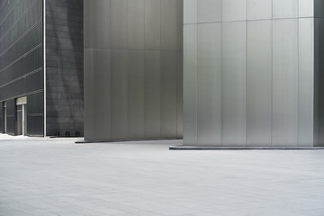 Empty ground in front of modern steel wall buildings .