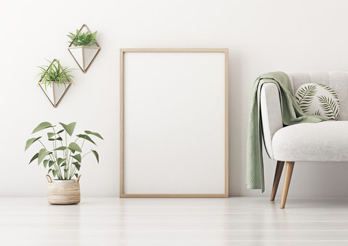 Poster mockup with vertical frame standing on floor in living room interior with gray sofa, round pillow, green plaid and plant in basket on empty white wall background. 3D rendering.