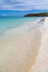 Looking along a sandy Antiguan beach on a sunny day