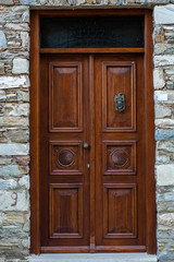 Medieval closed wooden door on a stone wall