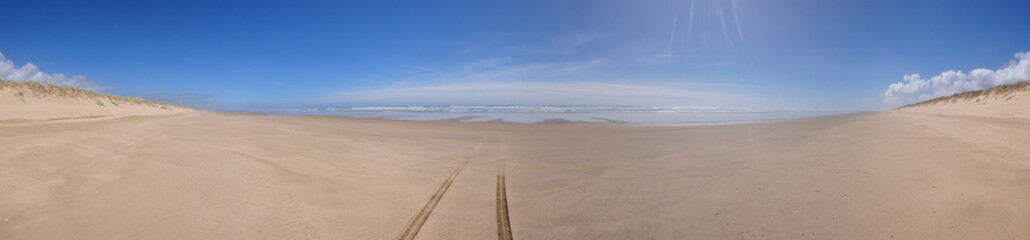 Panorama of tyre tracks in the sand on 90 mile beach in New Zealand 