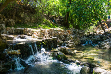 Naklejka na ściany i meble A small waterfall on the river on a sunny day in Rhodes in Greece.