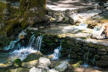 A small waterfall on the river on a sunny day in Rhodes in Greece.