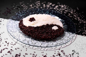 Black and white rice Ying Yang shape on transparent plate, flatlay