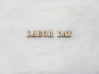 Wooden letters with a congratulatory inscription LABOR DAY. Close-up, top view, isolated. Concept of preparing for the holiday. Congratulations for loved ones, relatives, friends, colleagues