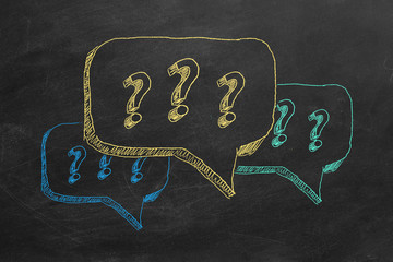 Hand drawing question marks  on blackboard.