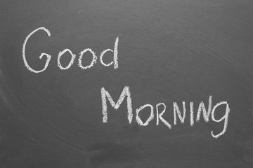 Handwritten inscription in chalk "good morning" on a gray chalkboard.