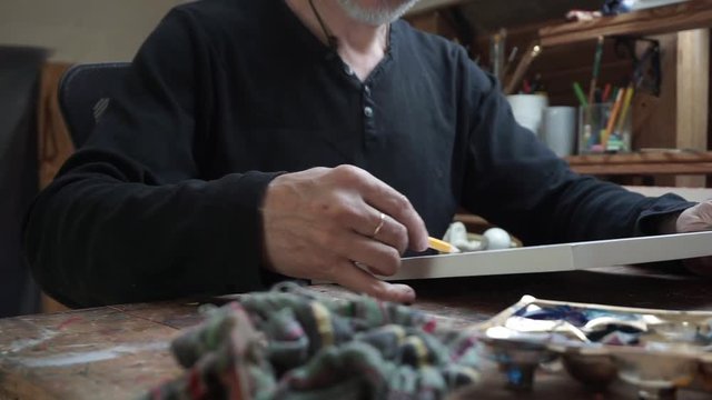 hands of male artist, drawing sketch at paper in the studio.
