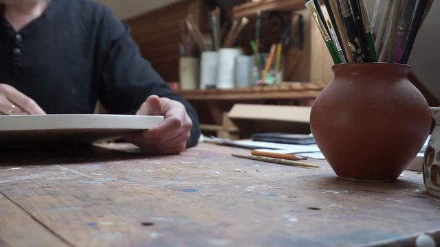 hands of male artist, drawing sketch at canvas