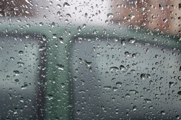 Raindrops on the window glass in the summer day