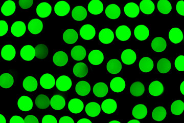 Unfocused abstract green bokeh on black background. defocused and blurred many round light