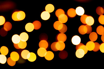 Fototapeta premium Unfocused abstract yellow bokeh on black background. defocused and blurred many round light