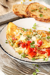 Homemade breakfast omelette with tomatoes, cheese and herbs