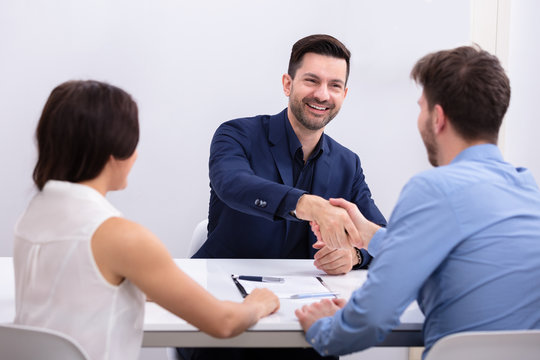 Woman Looking At Businessmen Shaking Hands