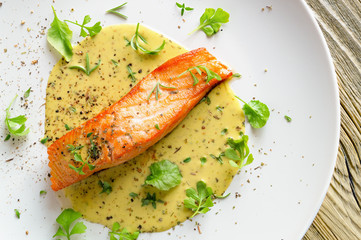 fried salmon with fresh garden cress, thyme, rosemary and dry spices in lemon-mustard sauce 