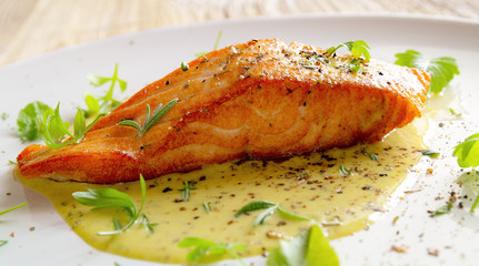 fried salmon fillet with fresh herbs and spices in lemon-mustard sauce