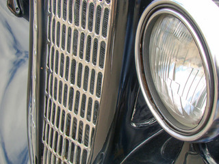 Antique passenger car. Black, chrome. Grille, headlight.