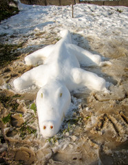 Snow sculpture alligator in the white snow. Crocodile made of snow.